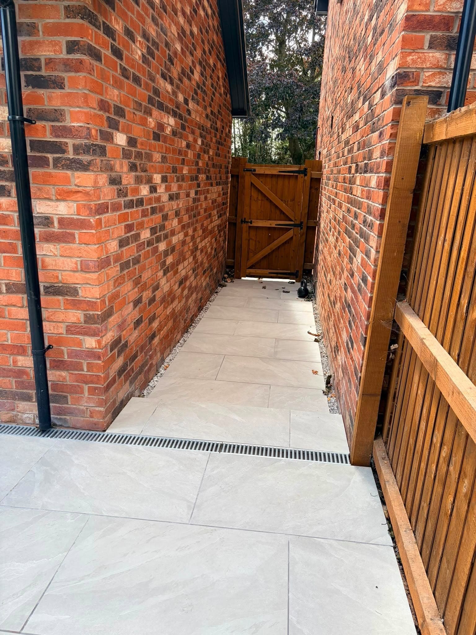 Neatly paved side access with gravel borders and drainage channel