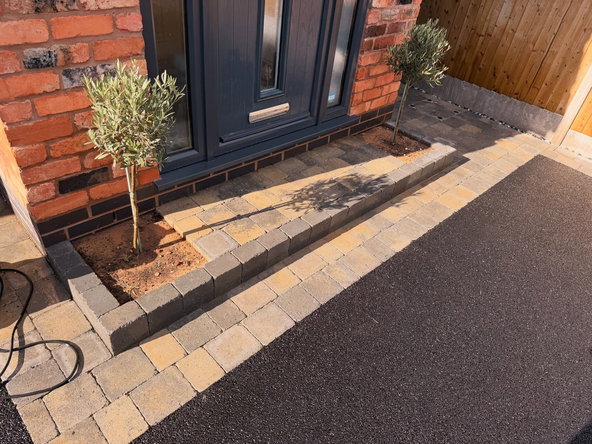 Detailed block paving edge and planting beside a CRF tarmac driveway